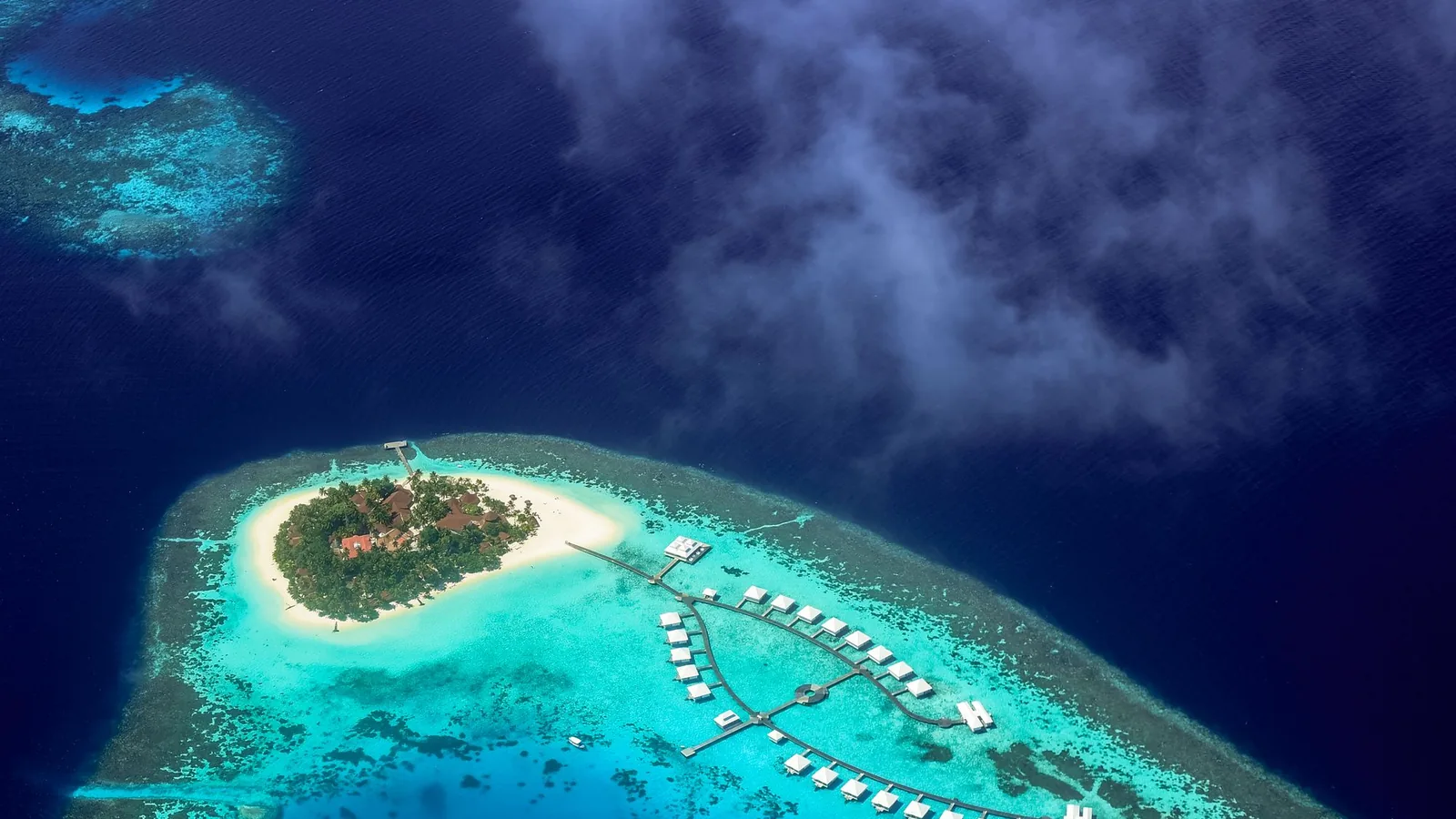 Aerial view of a small island surrounded by turquoise lagoon