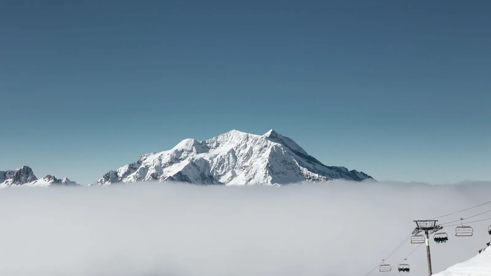 Snowy peak rising above the clouds near Val d'Isère