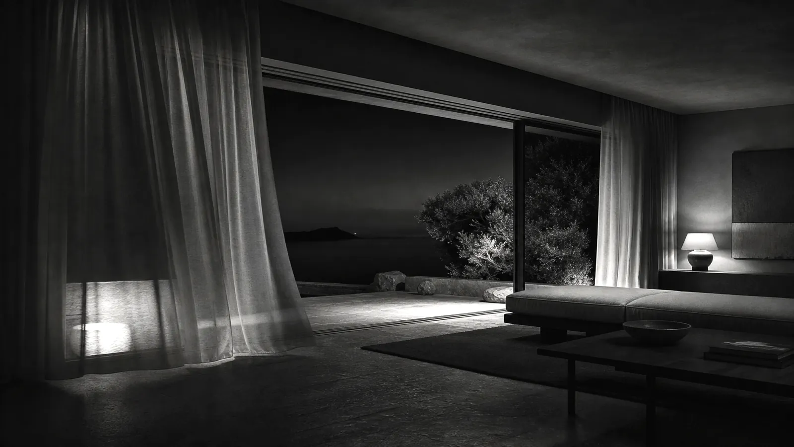 Villa living space opening to a terrace at night